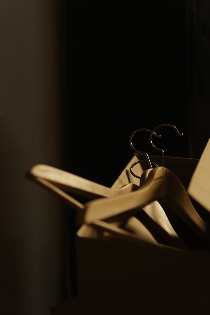 A detailed shot of wooden hangers inside a cardboard box, ideal for relocation or storage themes.